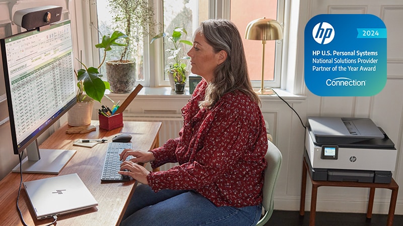 Woman using HP products - laptop, monitor and printer